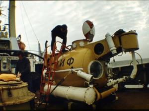 Леонид Бугров разувается перед посадкой в подводный аппарат "Риф" на палубе судна-носителя "Сатурн". Черное море, 1986 г.